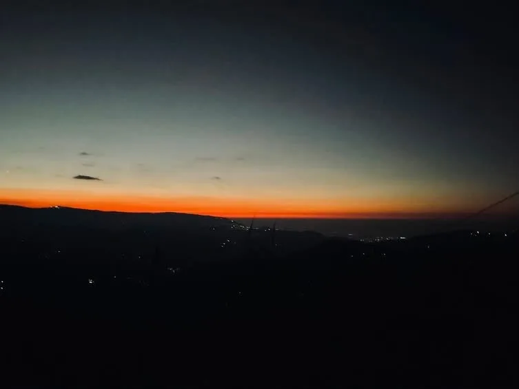 Crimson golden hour sunset skyline over distant Darjeeling mountain ridges seen from Zambala Dwelling Nest