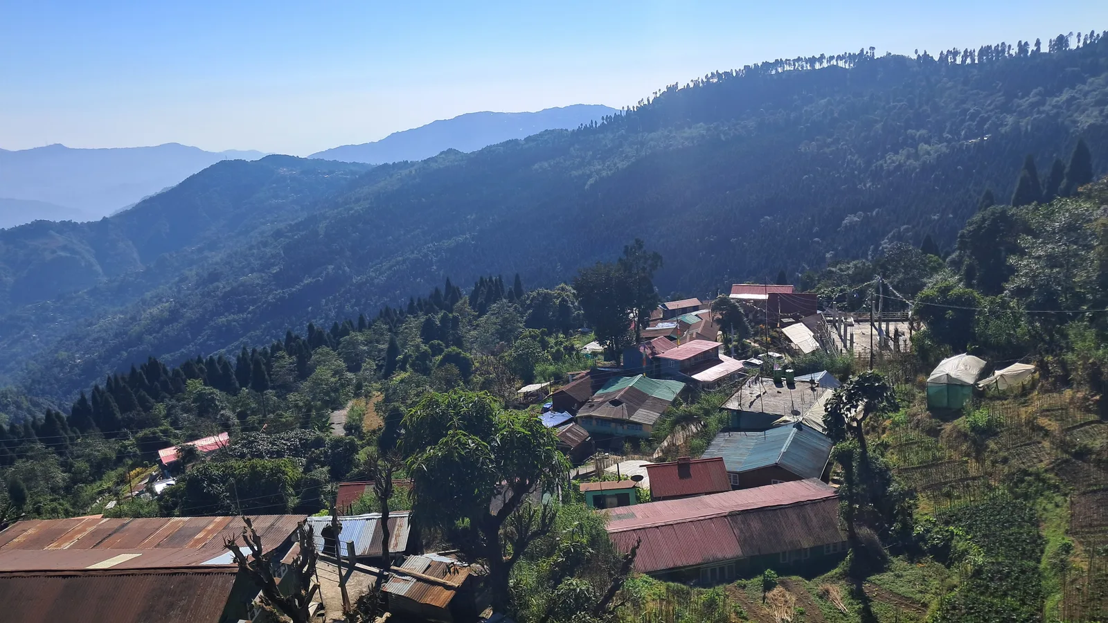 Panoramic landscape view of Sukhia Pokhari mountain valley and hill station village under clear blue skies