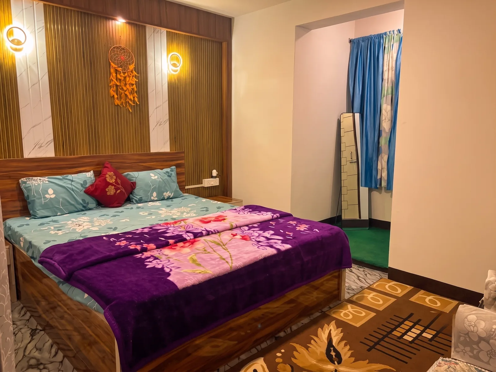 Executive King Suite main bed with plush purple blanket and wooden headboard at Zambala Dwelling Nest